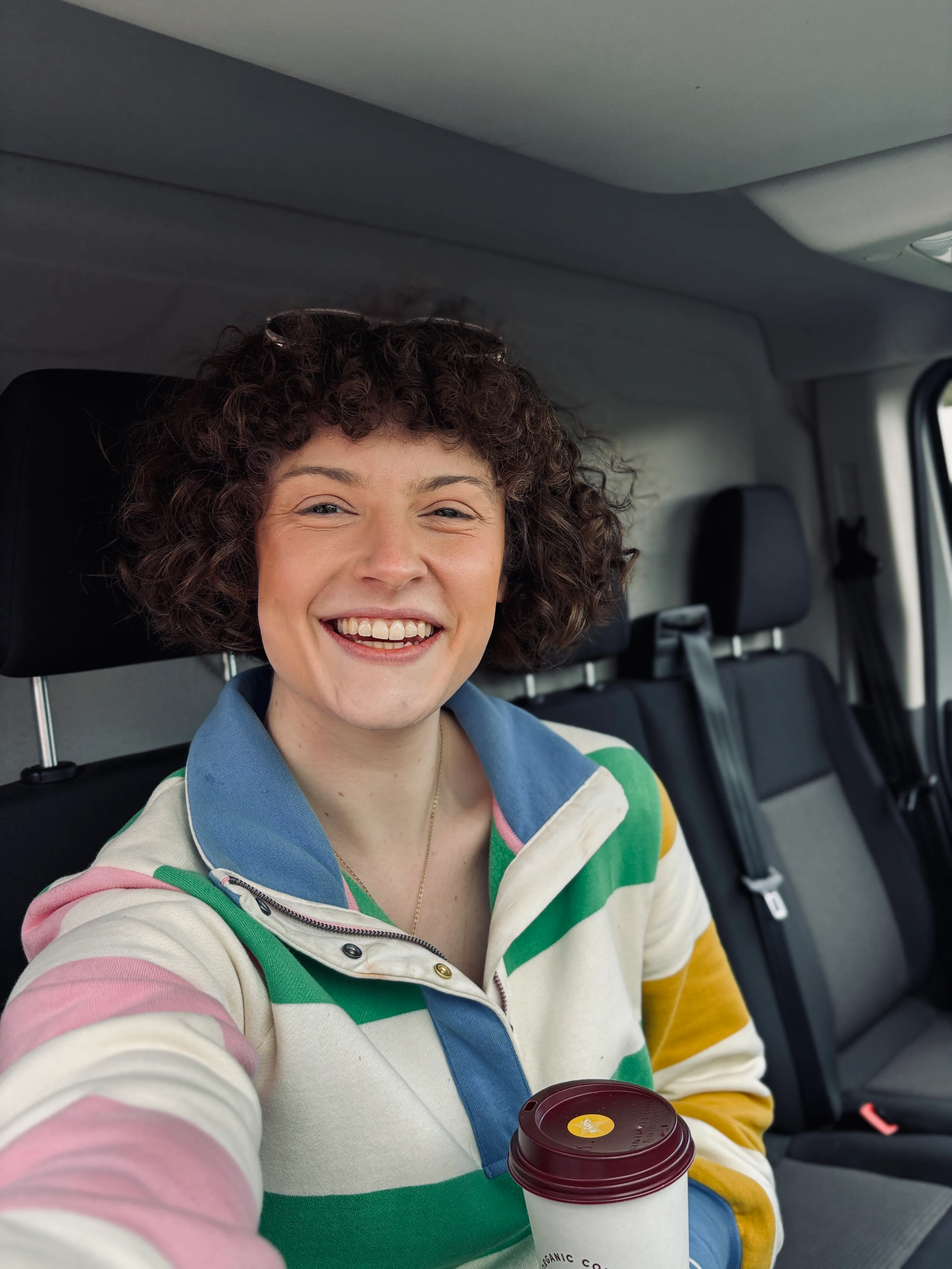 Hannah smiling inside her moving van after a London house move.